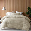 A cosy bed adorned with a natural quilt cover set, featuring a rich seersucker texture for added depth and warmth.