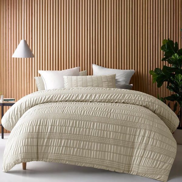 A cosy bed adorned with a natural quilt cover set, featuring a rich seersucker texture for added depth and warmth.