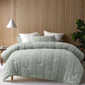 A bed adorned with a textured sage comforter set, providing a sophisticated and inviting bedroom atmosphere.