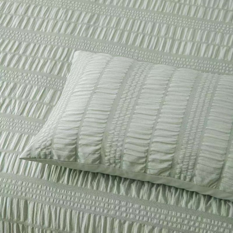 Close up details of a textured sage comforter set, providing a sophisticated and inviting bedroom atmosphere.