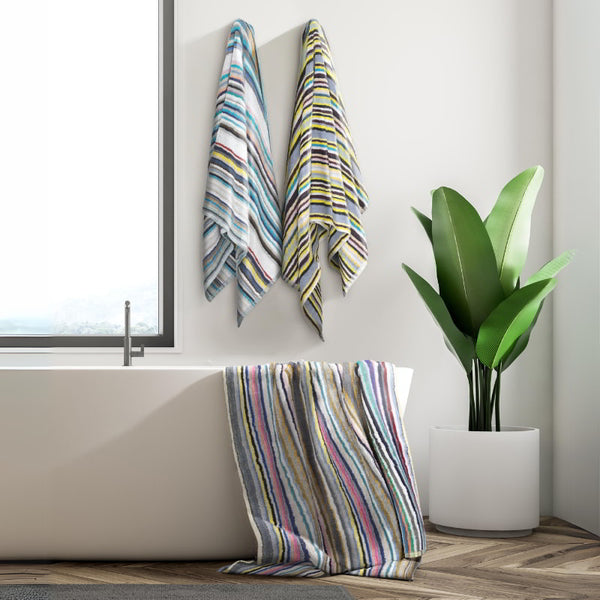 A vibrant, eco-friendly beach towel featuring multicoloured stripes, perfect for summer outings and stylish picnics in a bath tub.