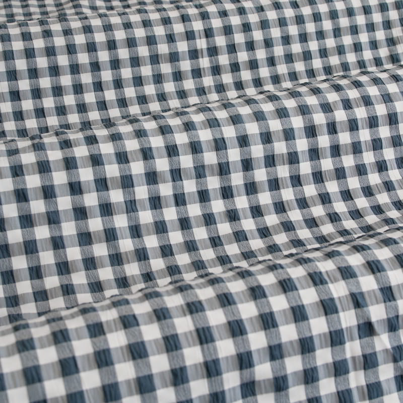 Detailed view of teal checkered fabric, featuring a charming gingham design that adds warmth to any bedroom.