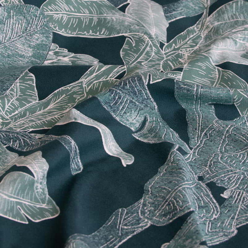  A stylish teal quilt cover with a green and white leaf pattern, perfect for creating a calming, tropical-inspired bedroom retreat.