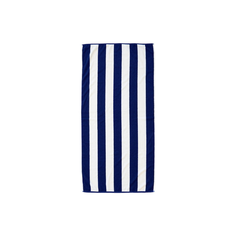 A blue and white beach towel featuring a white stripe, made from repurposed cotton for sustainable beach enjoyment.