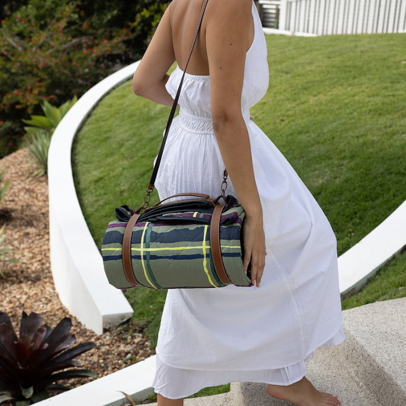 A woman in a white dress, poised for a picnic adventure with the stylish Bambury Felix Green Rug.