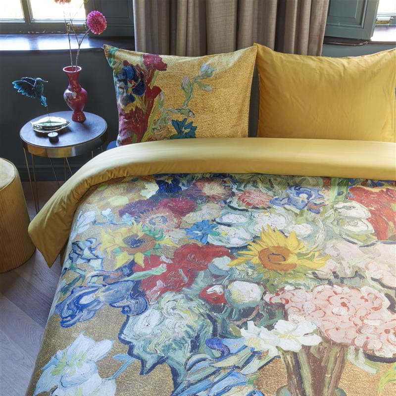 alt="Close-up look of a quilt cover featuring a bouquet of cut flowers from famous Van Gogh paintings on a golden background, with a solid golden-yellow underside."