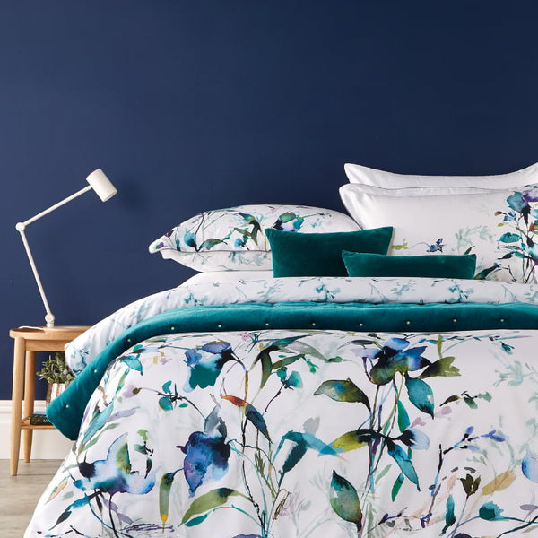 A serene bedroom featuring a gardenia prussian print quilt cover set, creating a tranquil and inviting atmosphere.