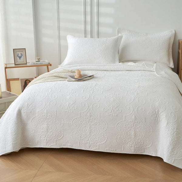 An elegant white quilted coverlet set creating a serene and inviting atmosphere for restful sleep.