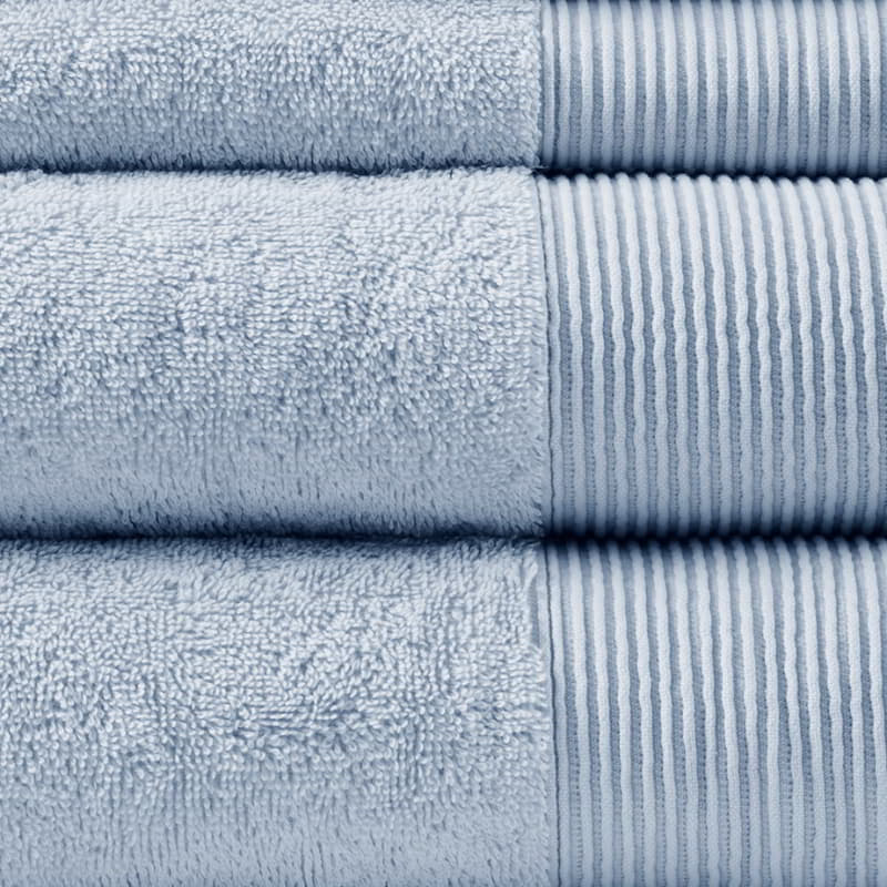 Detailed shot of a stack of luxurious blue towels made from eco-friendly Tencel and cotton, promoting sustainability and advanced hygiene.