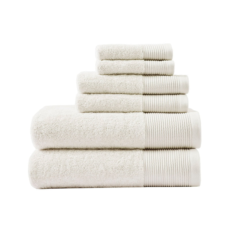 A stack of luxurious ivory towels made from eco-friendly Tencel and cotton, promoting sustainability and advanced hygiene.