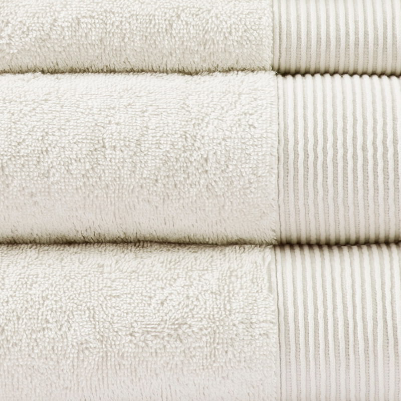 Detailed shot of a stack of luxurious ivory towels made from eco-friendly Tencel and cotton, promoting sustainability and advanced hygiene.