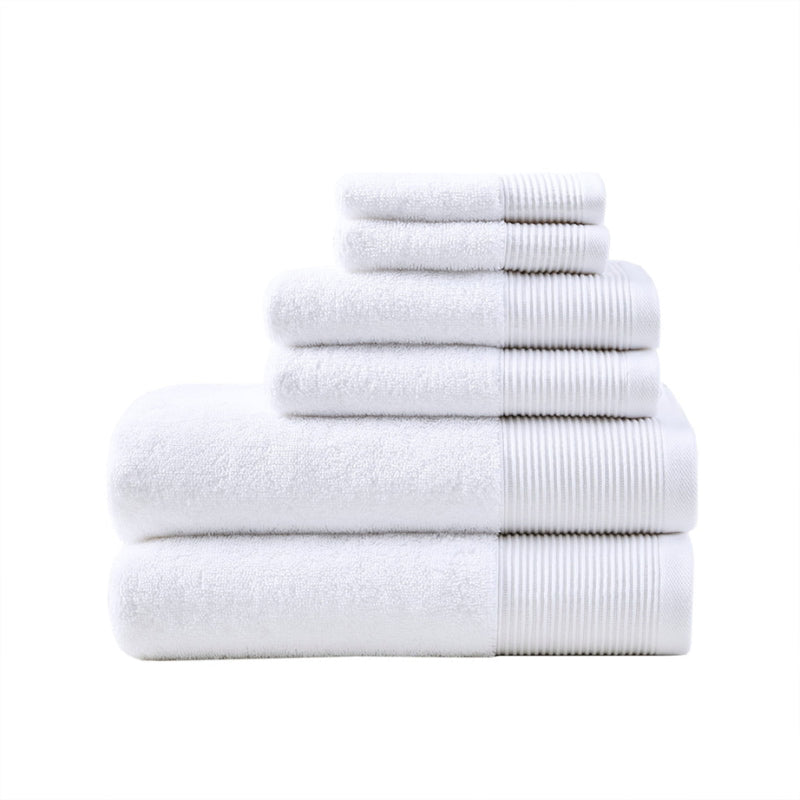 A stack of luxurious white towels made from eco-friendly Tencel and cotton, promoting sustainability and advanced hygiene.