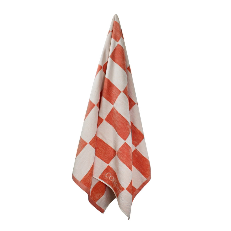 Hanging details of a calming coral checkerboard design towel, ideal for a tranquil beach day experience.