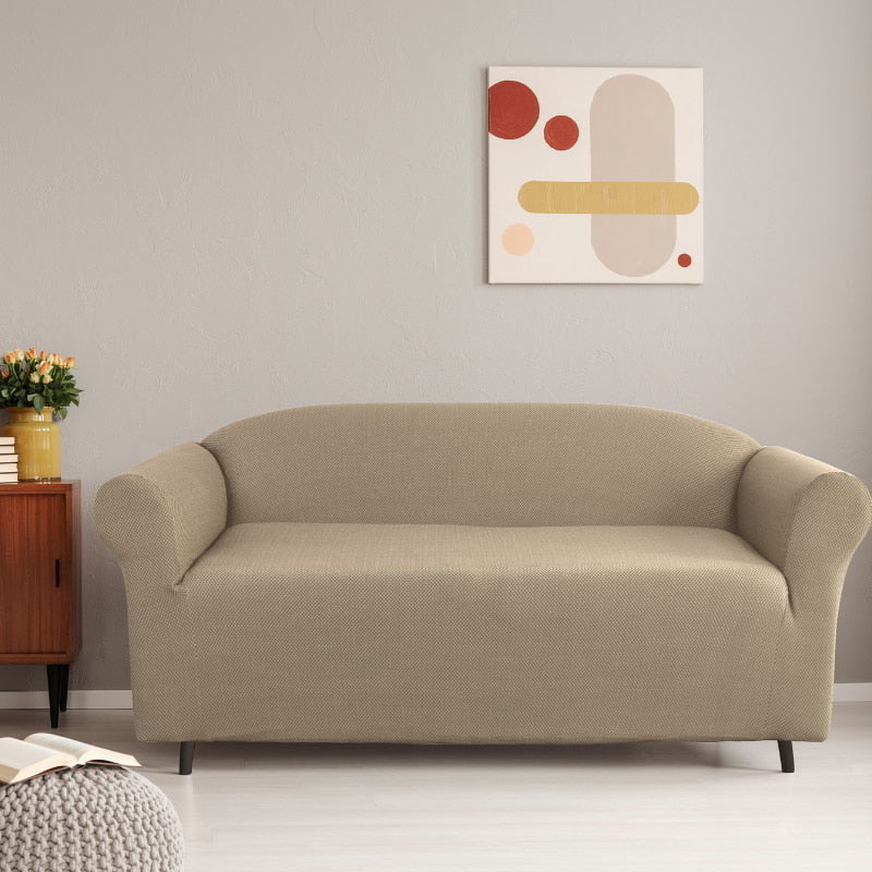 A 2-seater tan sofa cover is enhancing the aesthetic appeal and comfort of the surrounding environment.