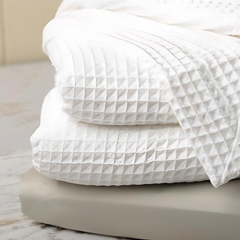 Detailed shot of a white blanket, showcasing a minimalist aesthetic and a sense of tranquility.