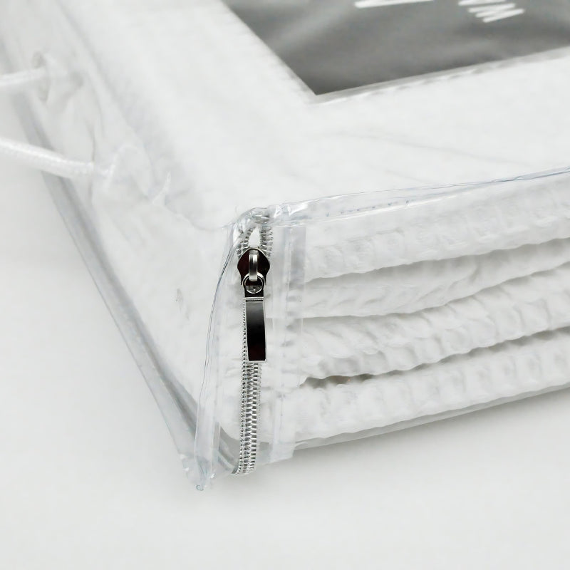 Closer look of detailed packaging of a white blanket, showcasing a minimalist aesthetic and a sense of tranquility.