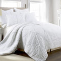 A white comforter and pillowcase create a serene and elegant bedroom atmosphere with classic ruffle design and luxurious comfort.