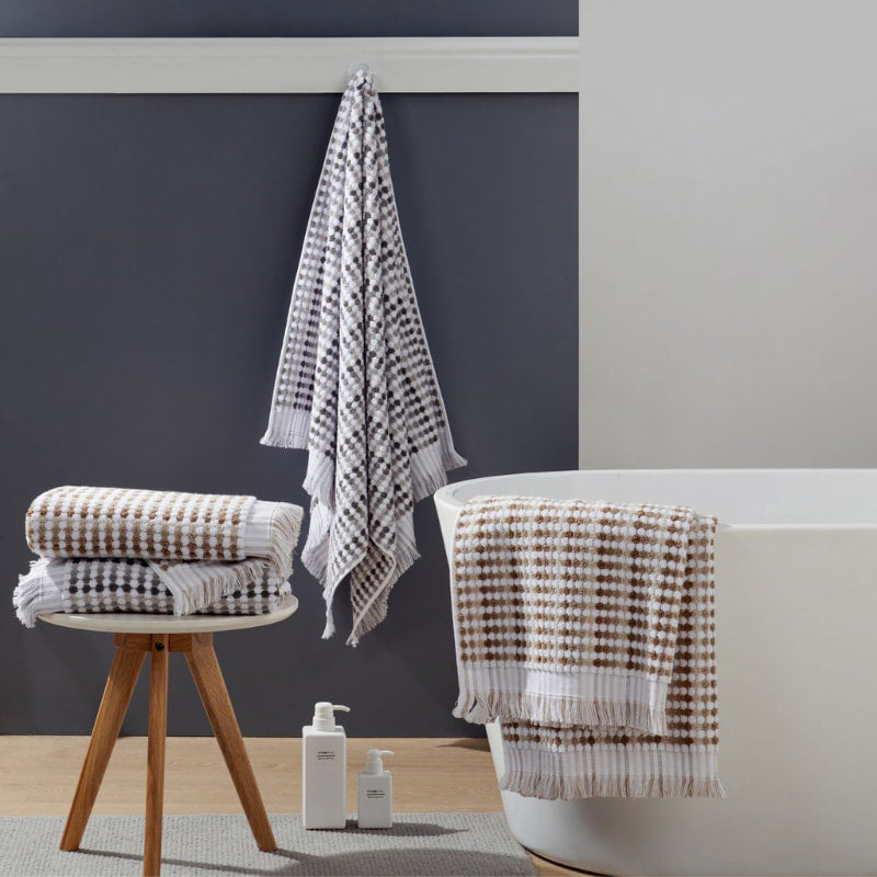 Elegant stack of towels featuring a  checker pattern, made of 100% cotton for ultimate softness and absorbency.