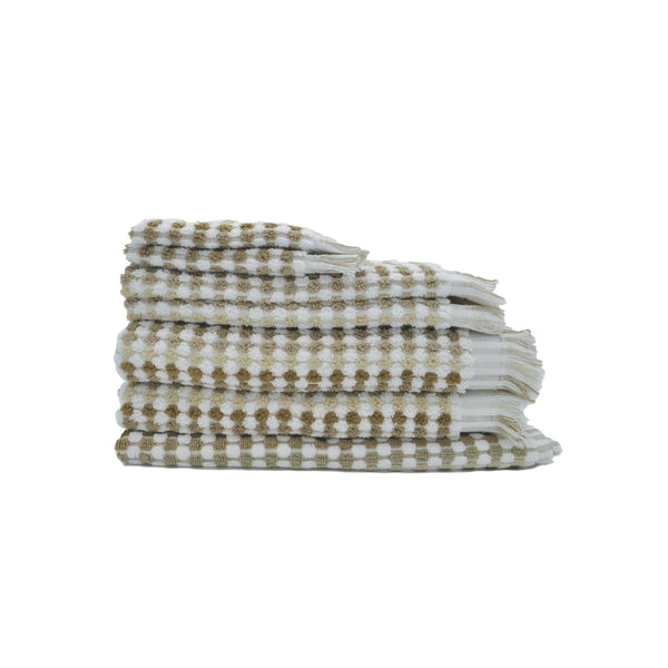 A stack of natural and white checker-patterned towels, showcasing luxurious softness and stylish pom-pom fringes for elegant decor.