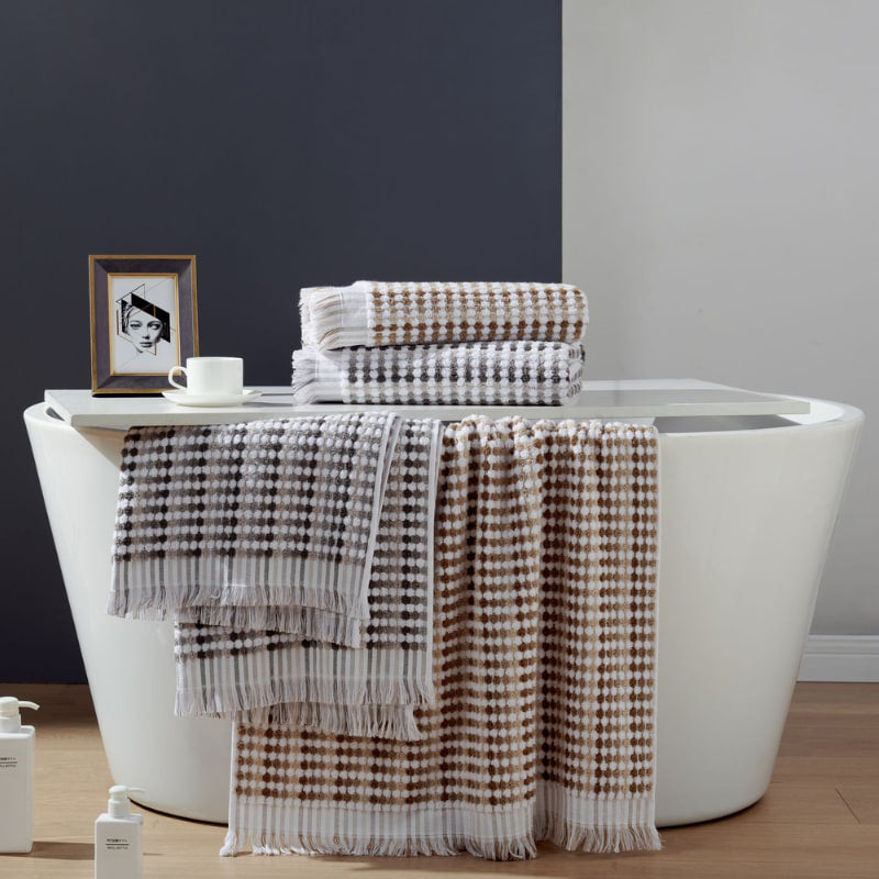 Elegant bathroom scene with a white tub, black wall, and bath linens, highlighting the softness and absorbency of cotton towels.