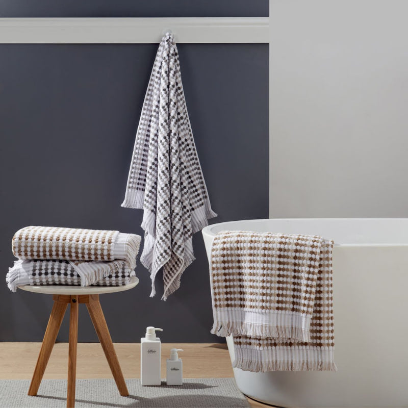 Modern bathroom design with a white tub, black wall, and bath linens, emphasizing the comfort and style of premium cotton towels.