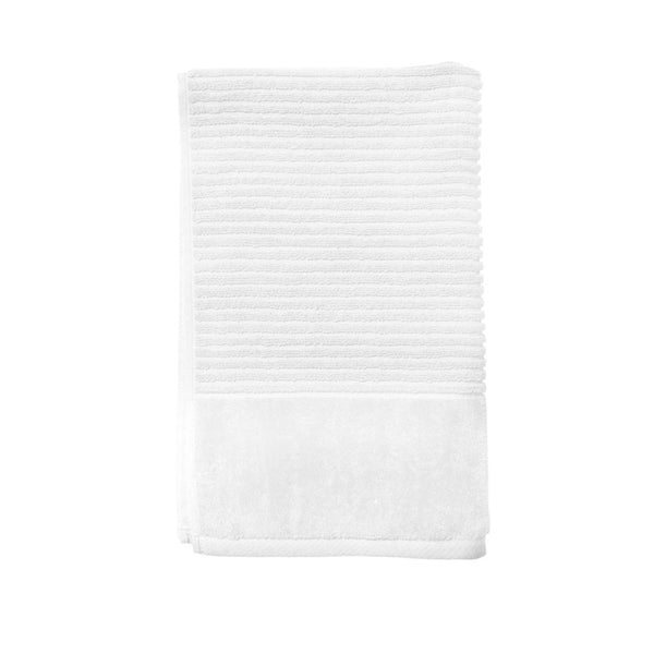 A white hand towel elegantly folded against a white backdrop, emphasizing its softness and stylish appeal for a cosy bathroom vibe.