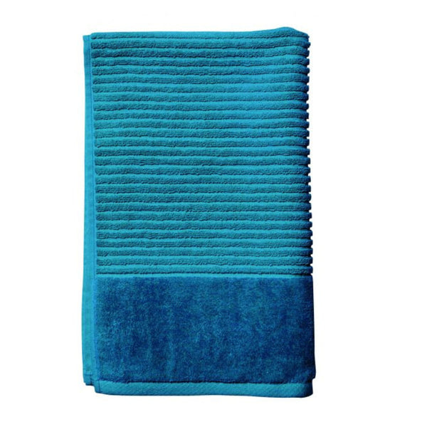 A teal hand towel elegantly folded against a white backdrop, emphasizing its softness and stylish appeal for a cosy bathroom vibe.