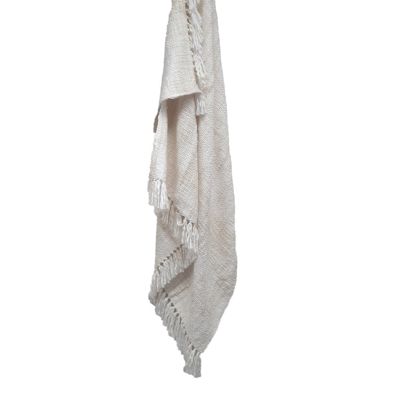 A natural throw with fringes, designed to enhance comfort and joy in any space, indoors or outdoors.