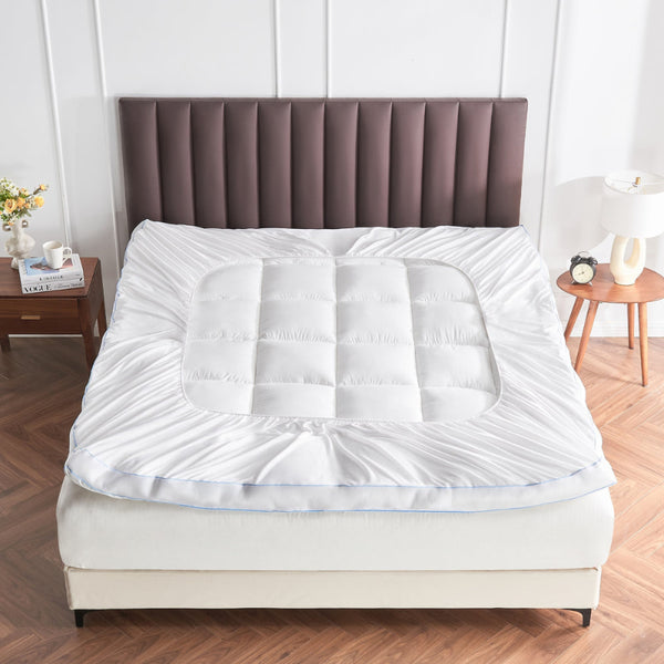 A stylish bed adorned with a white mattress, featuring a bamboo mattress topper that promotes cooling and comfort.