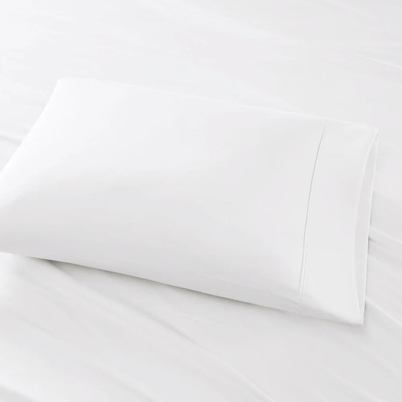 A white pillow is placed on a bed, highlighting the elegance of the Park Avenue Egyptian Cotton Sateen Sheet Set.