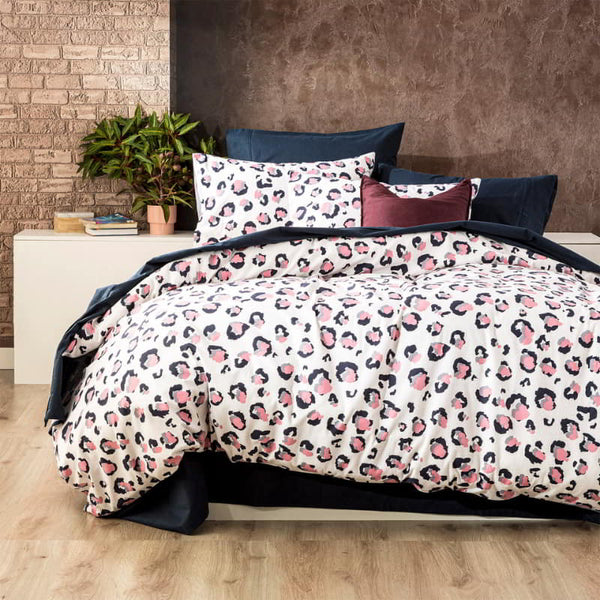 A stylish bed featuring a white and pink leopard print quilt cover, designed for warmth and softness during cold winter nights.