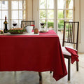 The dining table is adorned with a red tablecloth, featuring a sophisticated hemstitch border that elevates the setting.