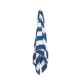 A stylish beach towel featuring white and cobalt blue stripes, elegantly displayed on a hook for easy access and drying.