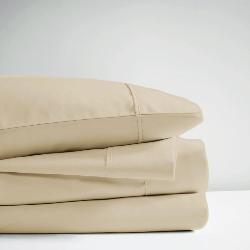 A stack of bone sheet set, showcasing the luxurious 700 Thread Count Renee Taylor Sheet Set.