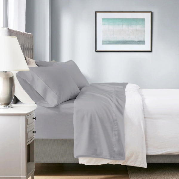 A neatly made bed featuring a dove sheet and dove pillowcases, showcasing the softness and breathability of the Renee Taylor Sheet Set.