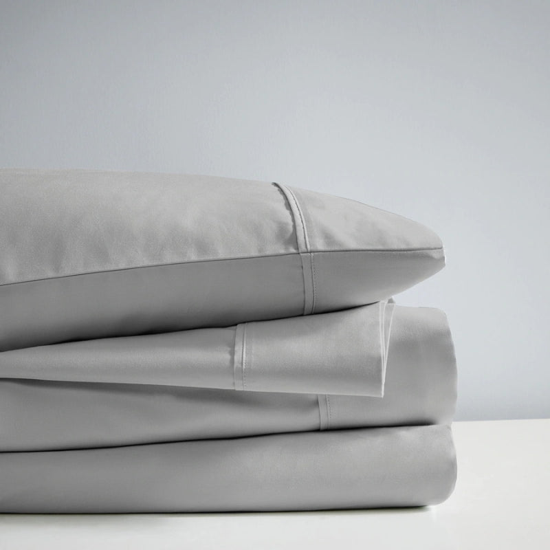 A stack of dove sheet set, showcasing the luxurious 700 Thread Count Renee Taylor Sheet Set.