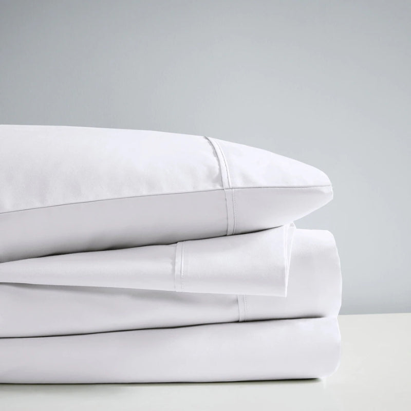 A stack of white sheet set, showcasing the luxurious 700 Thread Count Renee Taylor Sheet Set.