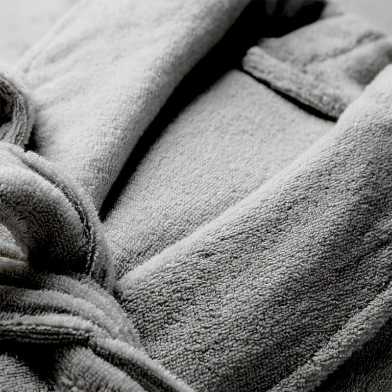 Zoom in details of a grey robe featuring a sleek style and front pockets, perfect for a comfortable home spa experience.