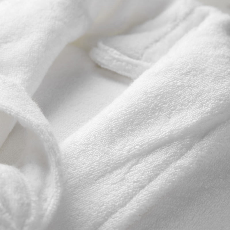 Closer look of a white robe featuring a sleek style and front pockets, perfect for a comfortable home spa experience.