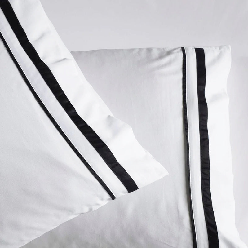 Zoom in details of the opulent Renee Taylor Cloud Pillowcases featuring 1000-thread count Egyptian cotton, available in white with chic charcoal edges.