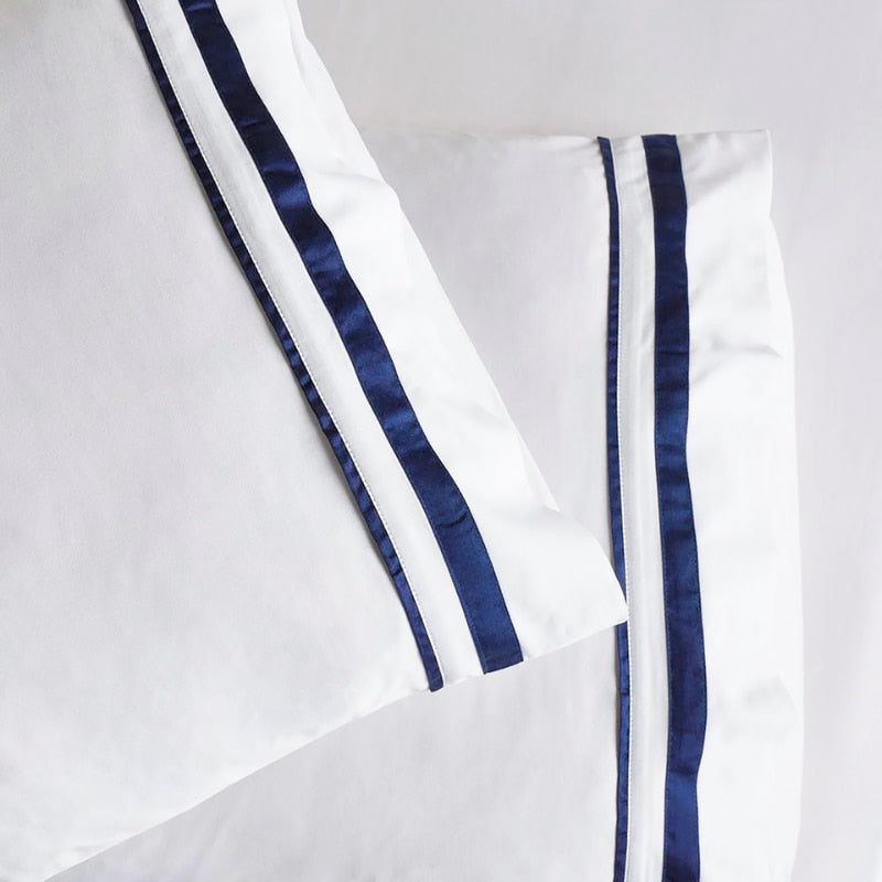 Opulent Renee Taylor Cloud PIllowcases featuring 1000-thread count Egyptian cotton, available in white with chic navy edges.