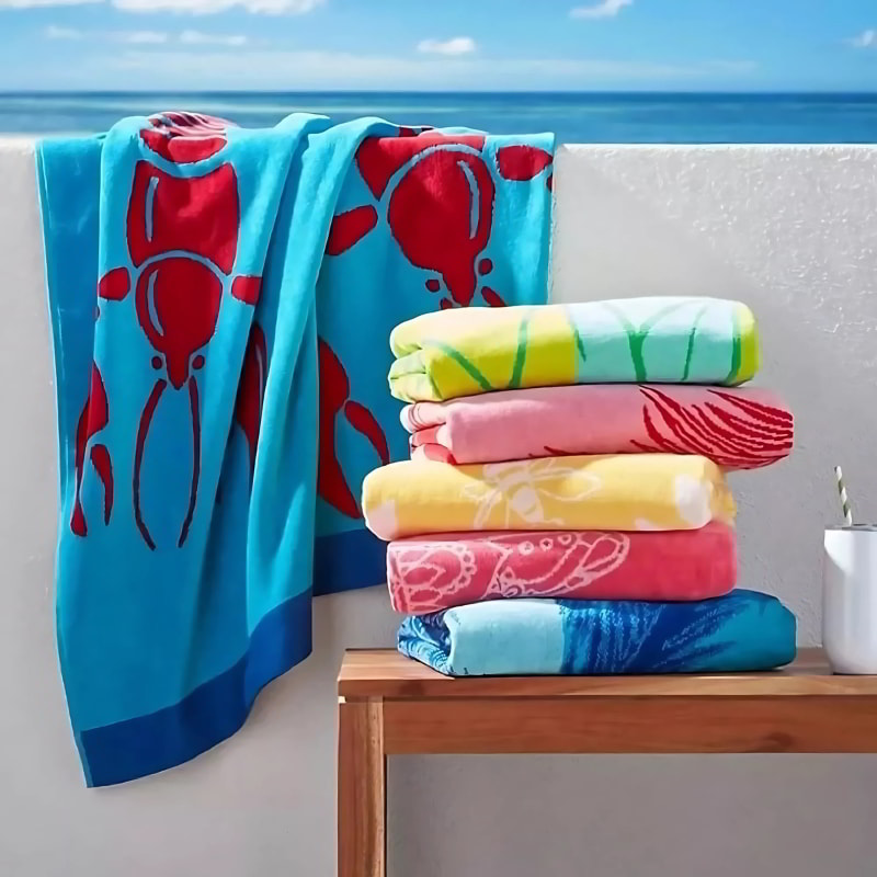 A neatly arranged stack of absorbent and colourful towels including the bee design, perfect for beach or spa use.