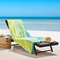 A beach chair adorned with a vibrant palm leaf beach towel, showcasing luxurious comfort and stylish design for relaxation.