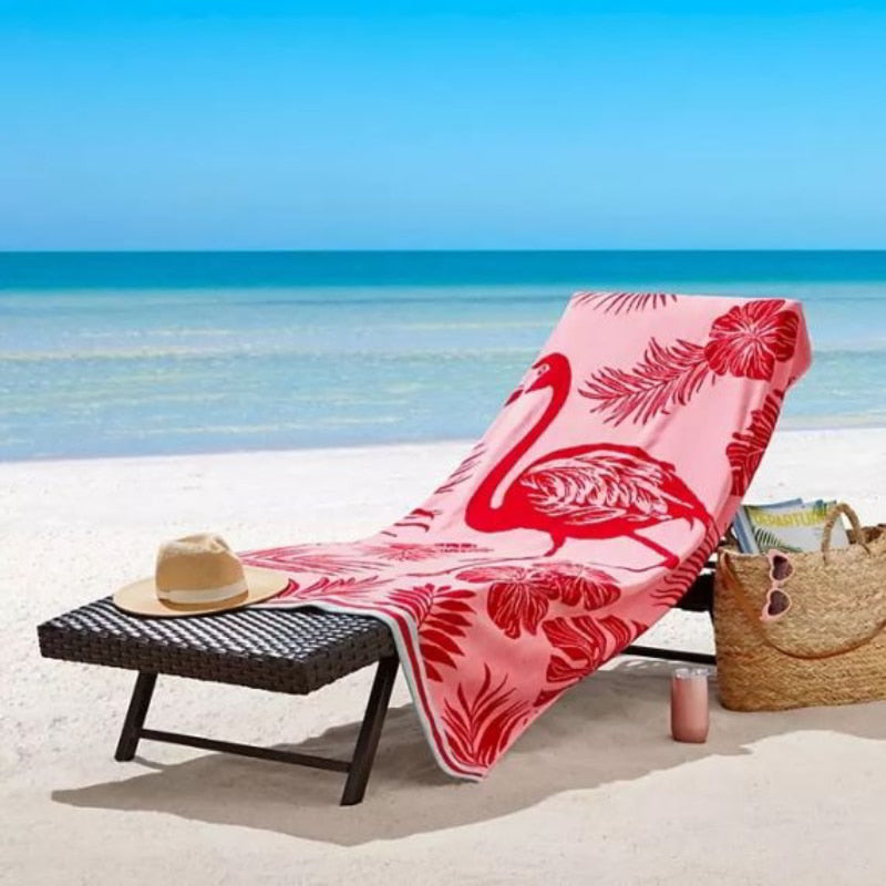 A beach chair adorned with a vibrant pink flamingo beach towel, showcasing luxurious comfort and stylish design for relaxation.