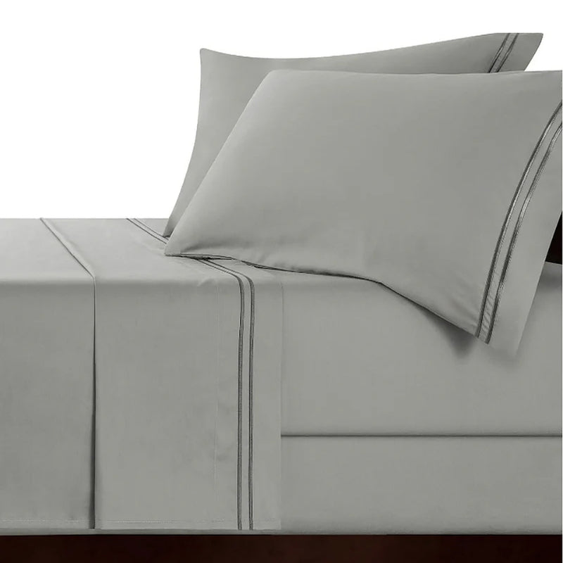 An elegant bed with a silver charcoal sheet set, emphasizing the luxurious feel and intricate embroidery of high-quality cotton.