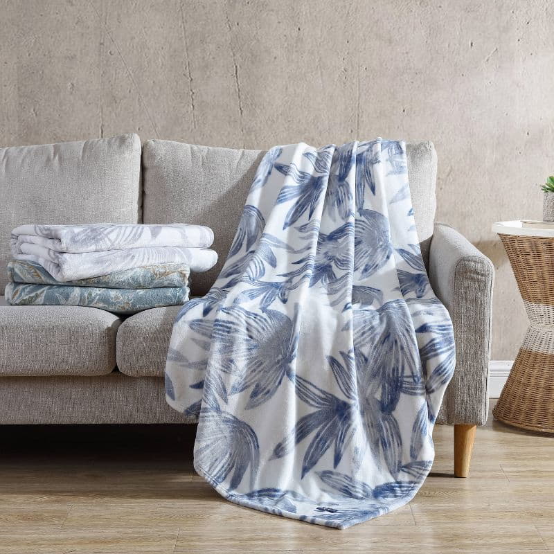 Soft plush polyester throw with tranquil blues palm leaf design for warmth too your living space.