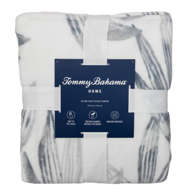 Packaging details of a soft plush polyester throw with soft grey hue palm leaf design for warmth.