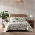 A tropical print quilt cover set featuring green and gold tones enhances a cosy bedroom atmosphere for restful sleep.