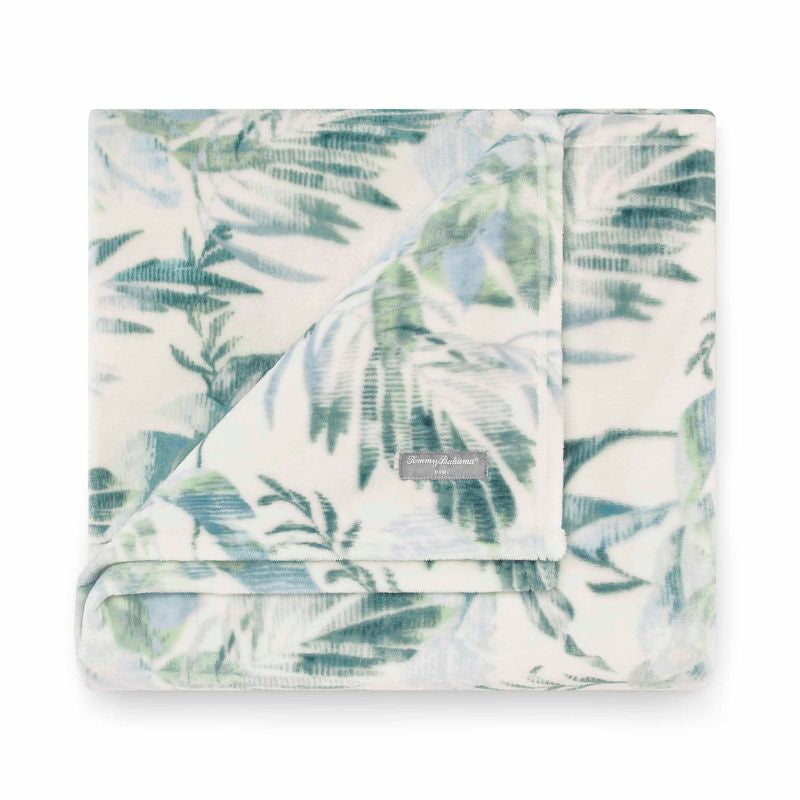 A super-soft, white and green tropical print blanket, featuring lush foliage, perfect for adding a touch of paradise to your home decor.