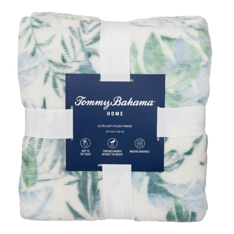 Packaging details of a super-soft, white and green tropical print blanket, featuring lush foliage, perfect for adding a touch of paradise to your home decor.